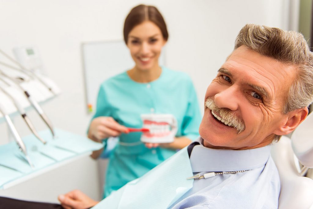 Mirthful senior citizen smiling during a dental treatment