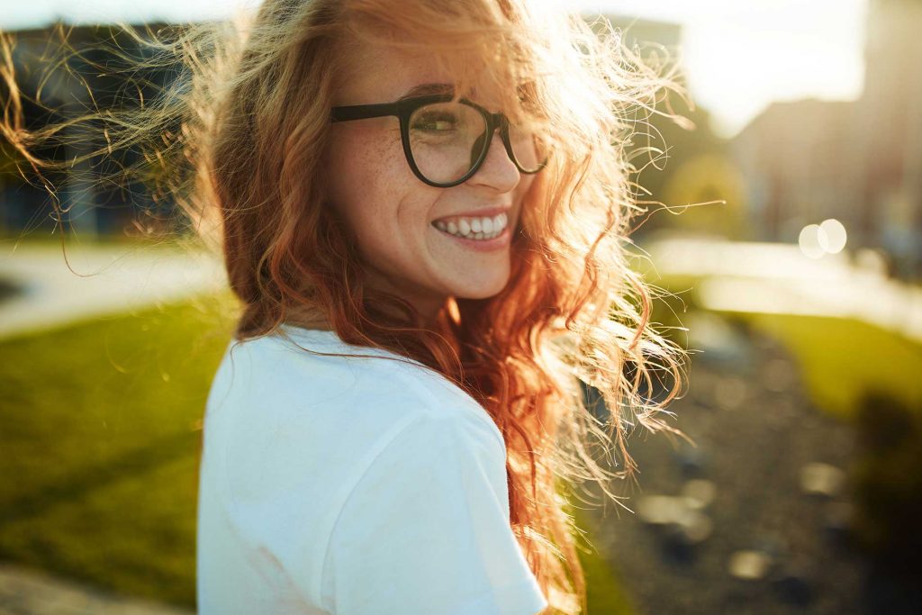 women smiling with glasses on while outside