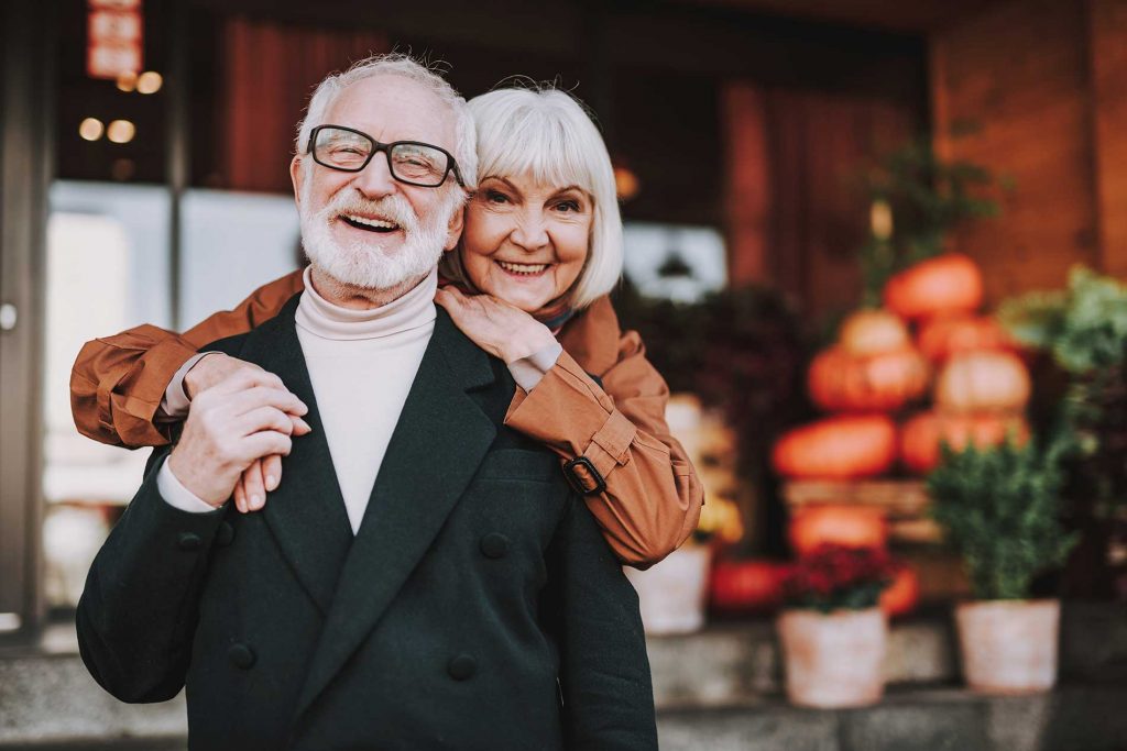 elderly-couple-smiling-outside-a-local-store