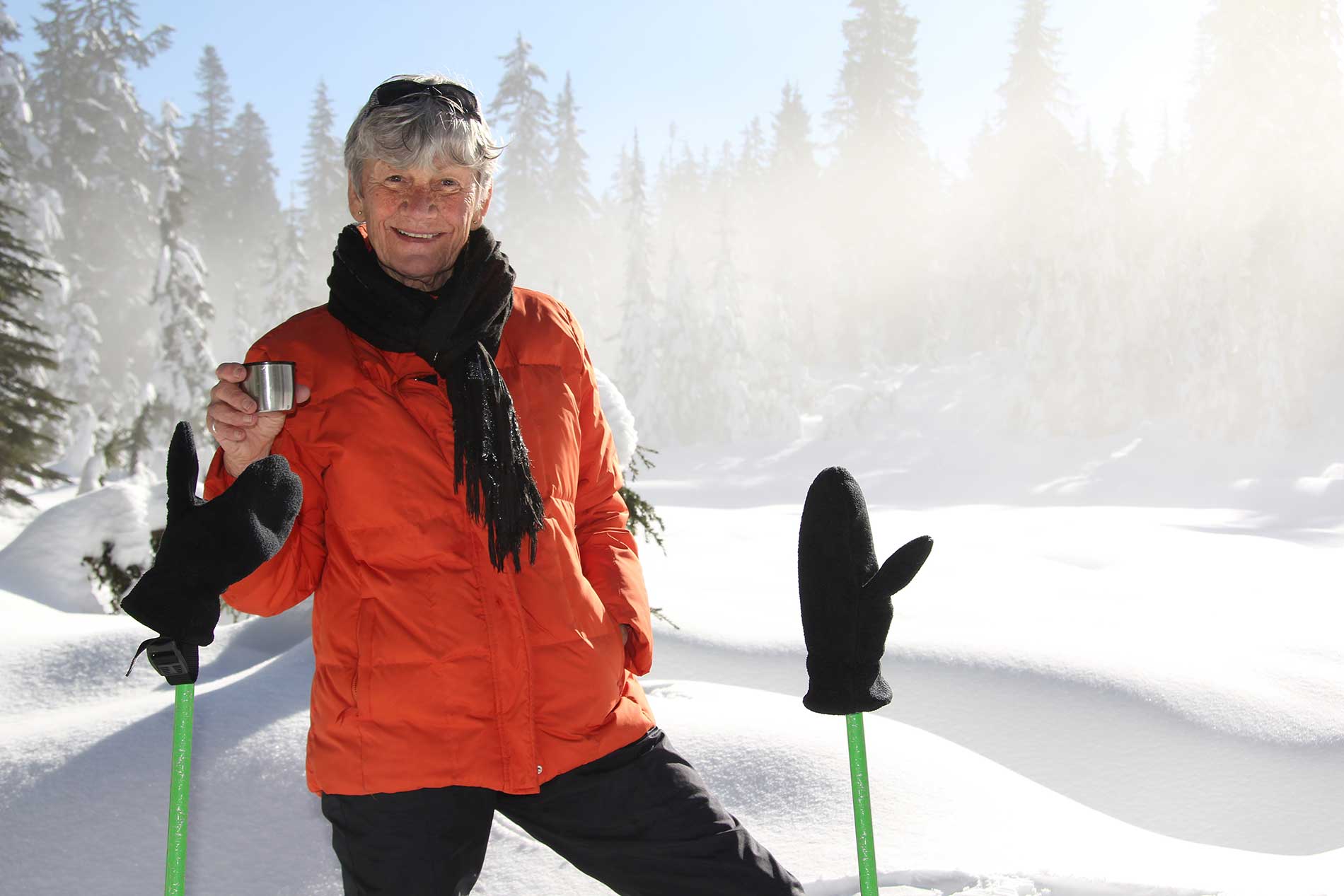 elderly woman having a drink on the ski hill