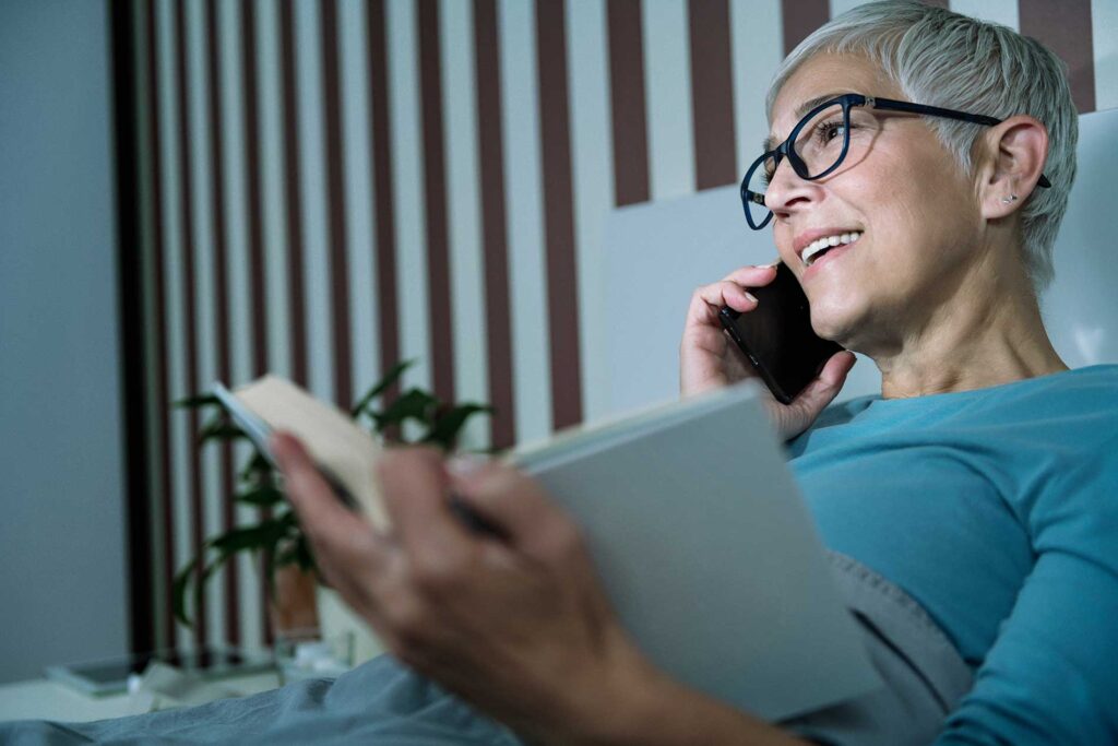women-on-the-phone-reading-at-night-with-a-smile
