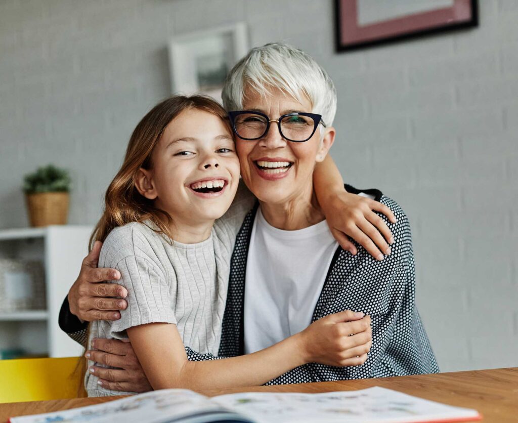 elderly woman smiling and hugging a girl elderly woman smiling and hugging a girl