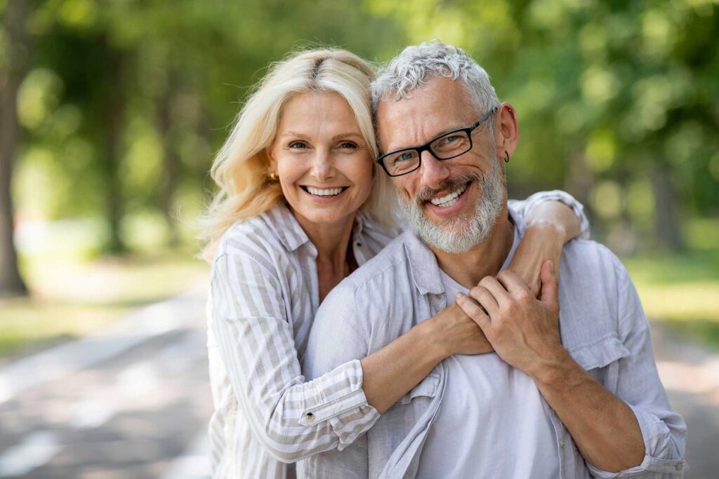 a senior couple smiling in a park a senior couple smiling in a park