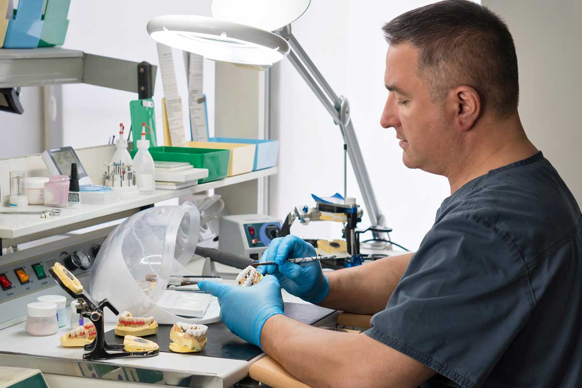 Dental technician working with tooth denture