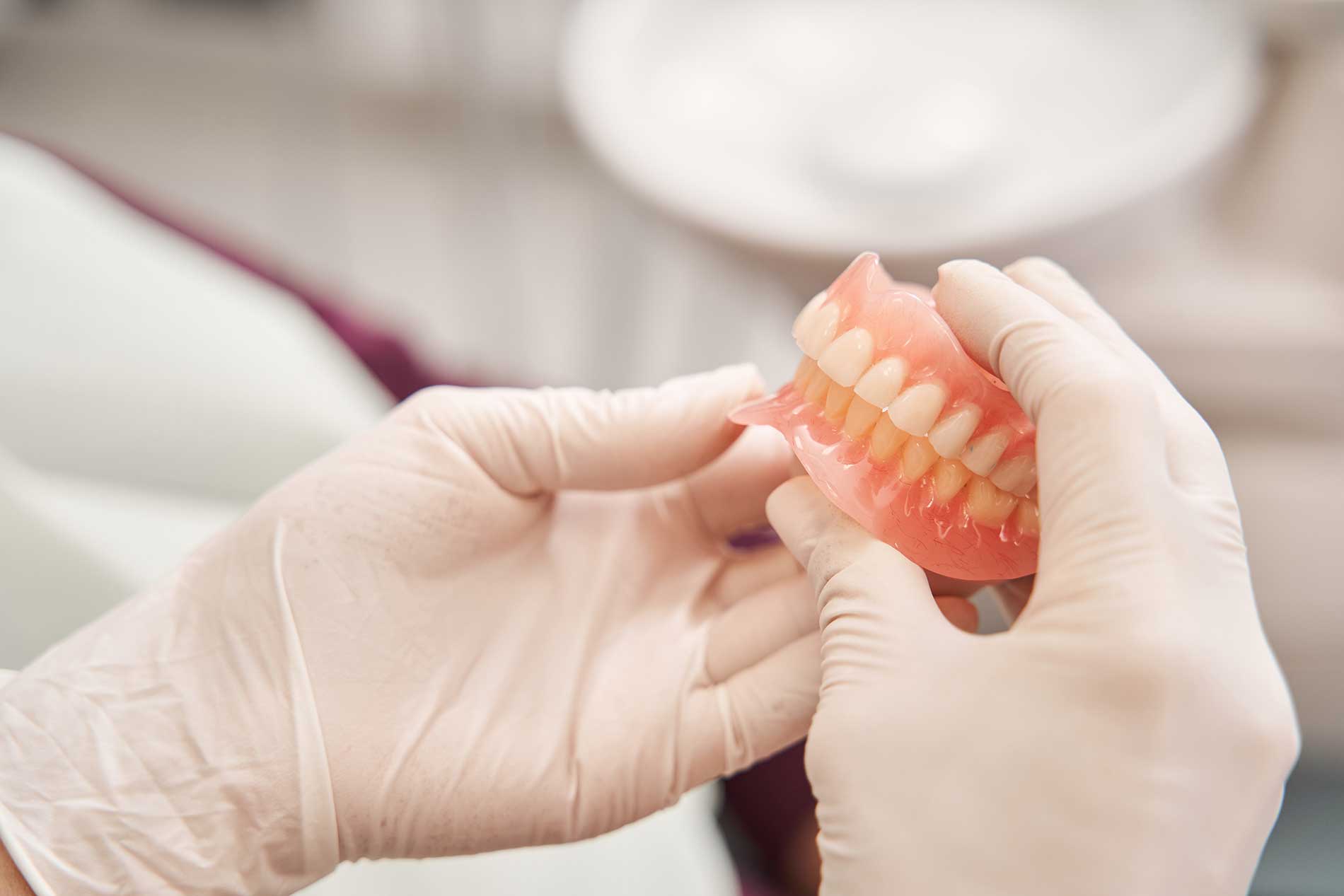 Dentist-looking-at-dentures Dentist-looking-at-dentures